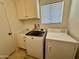 Bright laundry room with washer, dryer, cabinets, and utility sink at 4829 E Lake Point Cir, Phoenix, AZ 85044