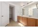 Double vanity bathroom with wood cabinets and large mirror at 5211 W Maldonado Rd, Laveen, AZ 85339