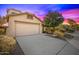 Tan colored house with a two-car garage and driveway at 5211 W Maldonado Rd, Laveen, AZ 85339