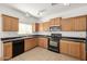 Kitchen with wood cabinets, black appliances, and granite counters at 5211 W Maldonado Rd, Laveen, AZ 85339