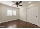 Bright bedroom with wood floors, ceiling fan, and double doors to closet at 616 E Country S Plz, Gilbert, AZ 85234