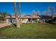 Charming single-story home with a well-manicured lawn, lush landscaping, and a cozy porch with blue chairs at 616 E Country S Plz, Gilbert, AZ 85234