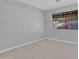 Bright bedroom with neutral walls and carpeting, featuring a large window at 6554 E Dallas St, Mesa, AZ 85205