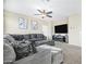 Living room with sectional sofa, large TV, and ceiling fan at 8709 W Hammond Ln, Tolleson, AZ 85353