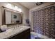 Updated bathroom with granite countertop and patterned shower curtain at 9215 W Raintree Dr, Sun City, AZ 85351