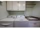 Bright laundry room, washer, dryer, cabinets and granite countertop at 9215 W Raintree Dr, Sun City, AZ 85351