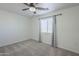 Well-lit bedroom with ceiling fan, window, and neutral carpeting at 9321 W Hillcrest Pl, Arizona City, AZ 85123