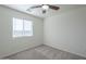 Charming bedroom with ceiling fan and window, featuring neutral carpeting at 9321 W Hillcrest Pl, Arizona City, AZ 85123