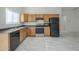 Modern kitchen with wood cabinets and black appliances at 9321 W Hillcrest Pl, Arizona City, AZ 85123