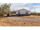 Side view of the house showing a gravel driveway and desert landscape at 1080 W Foothill St, Apache Junction, AZ 85120