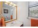 Clean bathroom with wood-framed mirror and orange towels at 109 E Milada Dr, Phoenix, AZ 85042