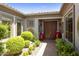 Elegant entryway with double doors, red planters, and lush greenery at 11175 N 121St Way, Scottsdale, AZ 85259