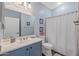 Bathroom featuring blue vanity and framed mirror at 12942 W Sola Dr, Sun City West, AZ 85375