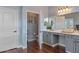 Bathroom features a spacious vanity, a toilet, and a open door to a linen closet and storage shelves at 12942 W Sola Dr, Sun City West, AZ 85375