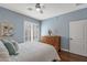 Light-filled bedroom with wood floors, white bedding, shutters and ceiling fan at 12942 W Sola Dr, Sun City West, AZ 85375