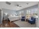 Comfortable bedroom with hardwood floors, plantation shutters, and cozy seating area for relaxing at 12942 W Sola Dr, Sun City West, AZ 85375