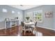 Bright dining area with hardwood floors, shuttered windows, and a decorative console table, offering a cozy setting at 12942 W Sola Dr, Sun City West, AZ 85375