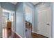 Hallway with wood floors leads to various rooms and office space beyond at 12942 W Sola Dr, Sun City West, AZ 85375