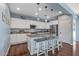 Bright kitchen boasts an island with bar seating, stainless steel appliances, and stylish pendant lighting at 12942 W Sola Dr, Sun City West, AZ 85375