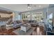 Comfortable living room area featuring hardwood floors, a large sectional sofa, and plantation shutters for ample natural light at 12942 W Sola Dr, Sun City West, AZ 85375