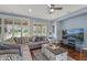 Cozy living room area features hardwood floors, a large sectional sofa and plantation shutters offering ample natural light at 12942 W Sola Dr, Sun City West, AZ 85375