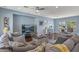 Inviting living room features hardwood floors, large sectional sofa, ceiling fan and an entertainment center at 12942 W Sola Dr, Sun City West, AZ 85375