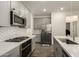Modern kitchen with gray cabinets, white quartz countertops, and stainless steel appliances at 14627 W Valentine St, Surprise, AZ 85379
