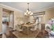 Bright dining room with a stylish chandelier, seating for six, and views into the kitchen and entryway at 18456 E Superstition Dr, Queen Creek, AZ 85142