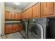 Laundry room with washer, dryer and wood cabinets at 18456 E Superstition Dr, Queen Creek, AZ 85142