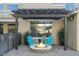 Cozy patio with fire pit and two teal chairs under a pergola at 18456 E Superstition Dr, Queen Creek, AZ 85142