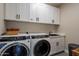 Laundry room with white cabinets, washer, dryer, and extra storage at 2743 N Lema Dr, Mesa, AZ 85215