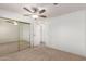 Bright bedroom with mirrored closet doors and ceiling fan at 430 S 81St Pl, Mesa, AZ 85208