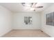 Bedroom with ceiling fan, neutral carpet, and two windows at 430 S 81St Pl, Mesa, AZ 85208