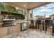 Outdoor kitchen with grill, refrigerator, and bar seating at 9968 W Jj Ranch Rd, Peoria, AZ 85383