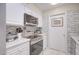 Modern kitchen with white cabinets, stainless steel appliances, and mosaic backsplash at 10533 W Wheatridge Dr, Sun City, AZ 85373