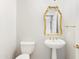 Elegant powder room with pedestal sink, gold accents, and ornate mirror at 10796 N 78Th St, Scottsdale, AZ 85260