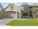 Tan two-story house with a stone turret, a large garage, and a manicured lawn at 10796 N 78Th St, Scottsdale, AZ 85260