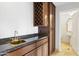 Wet bar with granite countertop, wooden cabinets, and wine rack at 10796 N 78Th St, Scottsdale, AZ 85260