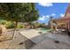 Large backyard with a swimming pool, gravel landscaping, and a covered patio at 13616 W San Miguel Ave, Litchfield Park, AZ 85340