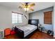 Bedroom with ceiling fan, wood floors, and a window with blinds at 13616 W San Miguel Ave, Litchfield Park, AZ 85340
