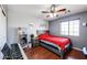 Cozy bedroom with red bedding, ceiling fan, and wood floors at 13616 W San Miguel Ave, Litchfield Park, AZ 85340