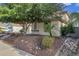 Side view of a two-story house with mature trees and rock landscaping at 13616 W San Miguel Ave, Litchfield Park, AZ 85340