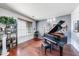 Music room featuring a grand piano, built-in shelving, and hardwood floors at 13616 W San Miguel Ave, Litchfield Park, AZ 85340