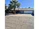 Single story home with a two-car garage and a palm tree in the front yard at 143 W Michelle Dr, Phoenix, AZ 85023