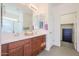 Bathroom with double vanity, large mirror, and linen closet at 17510 W Glenhaven Dr, Goodyear, AZ 85338