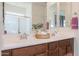 Double vanity bathroom with a large mirror and an adjacent shower at 17510 W Glenhaven Dr, Goodyear, AZ 85338
