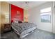 Bedroom with a red accent wall and patterned bedding at 17510 W Glenhaven Dr, Goodyear, AZ 85338