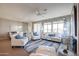 Bright living room with comfy seating, large windows, and a neutral color palette at 17510 W Glenhaven Dr, Goodyear, AZ 85338