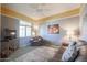 Living room with brown leather furniture, TV, and ceiling fan at 17510 W Glenhaven Dr, Goodyear, AZ 85338