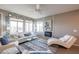 Relaxing living room featuring a stylish sofa, fireplace, and natural light at 17510 W Glenhaven Dr, Goodyear, AZ 85338